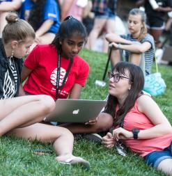 student group with laptop on grass